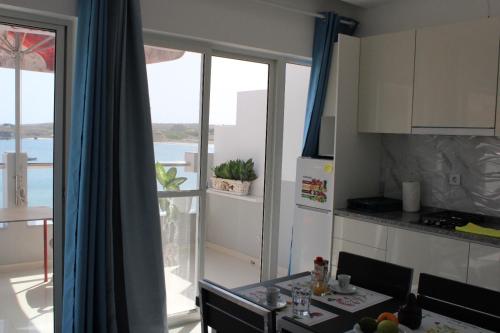 a kitchen with a dining table and a view of the ocean at Apartamentos vista ao mar in Praia Baixo
