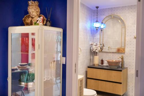 a bathroom with a toilet and a cabinet with a mirror at Portas da Cidade Home in Silves