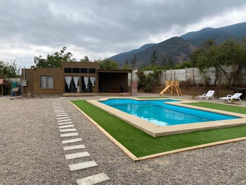 a swimming pool in a yard with a house at Olmue Cabaña in Olmué