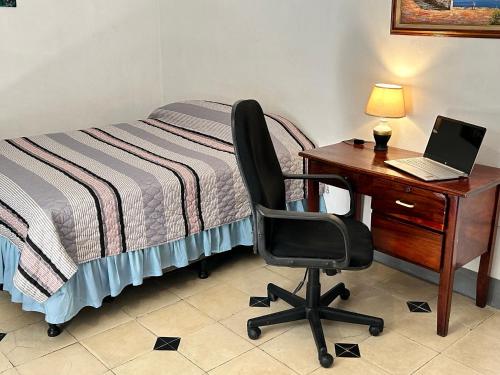 a bedroom with a desk and a chair and a bed at El Callejon Guest House in León