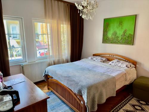 um quarto com uma cama e um lustre em Convini Bed & Bathroom Homestay em Pristina