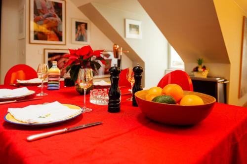 une table avec un bol de fruits sur une nappe rouge dans l'établissement Appartement Sauval - Welkeys, à Paris