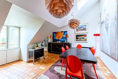 une salle à manger avec une table et des chaises rouges dans l'établissement Appartement Sauval - Welkeys, à Paris