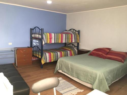 a bedroom with two bunk beds and a chair at Hospedaje familiar in Viña del Mar