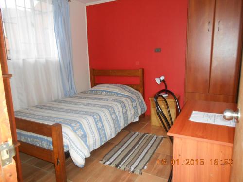 a small bedroom with a bed and a table at Hospedaje familiar in Viña del Mar