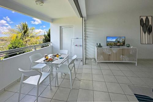 a dining room with a table and chairs on a balcony at Villa Ansalane in Quartiers Anse à lʼÂne
