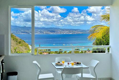 a table and chairs with a view of the ocean at Villa Ansalane in Quartiers Anse à lʼÂne