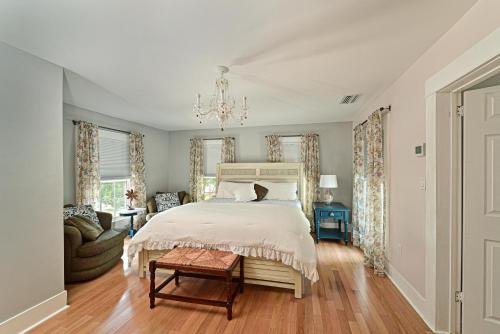 a bedroom with a large bed and a chandelier at The Gathering Place in Bradenton