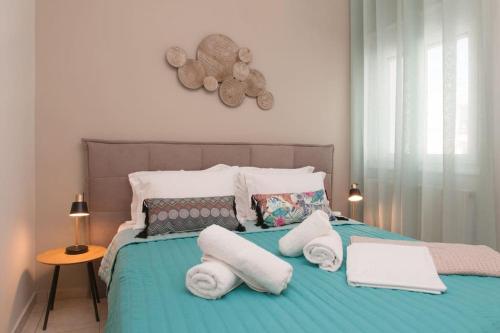 a bedroom with a bed with towels on it at Virginia's Luxury Suites 2 in Volos