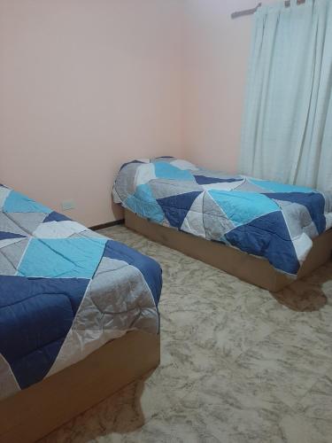 two beds sitting in a room with at La Casa de Zoe in Perito Moreno