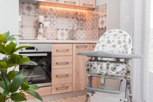 a kitchen with a chair in front of a stove at Virginia's Luxury Suites 2 in Volos