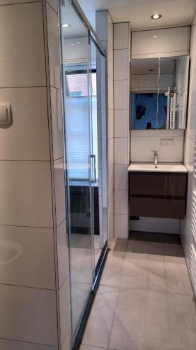 a bathroom with a glass shower and a sink at Karakteristiek huis in centrum Winsum met nieuwe badkamer in Winsum