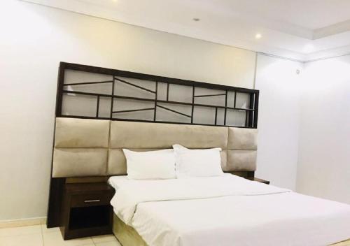 a bedroom with a large bed with white sheets at الحمدانية الراقي للأجنحة الفندقية in Jeddah