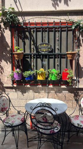 a table and chairs with potted plants on a fence at şekercigiller konuk evileri in Ayvalık