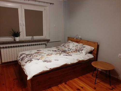 a bedroom with a bed and a table and a window at Noclegi w Dolinie Drwęcy in Kurzętnik