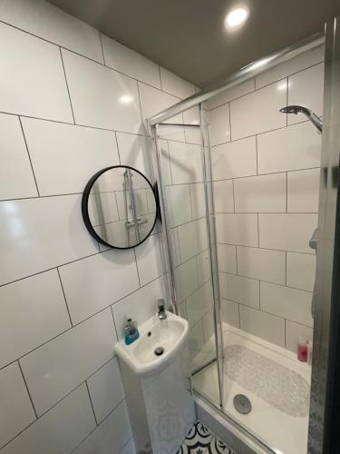 La salle de bains blanche est pourvue d'un lavabo et d'une douche. dans l'établissement CV1 City Stays - Short & Long Term Serviced Apartment No 7, à Coventry