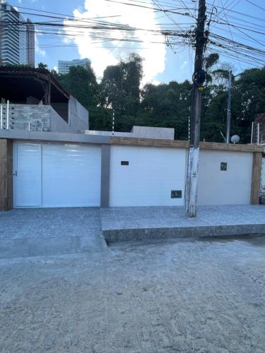 a building with two garage doors and a pole at Casa de Férias á 400m pra Praia de Cabo Branco in João Pessoa