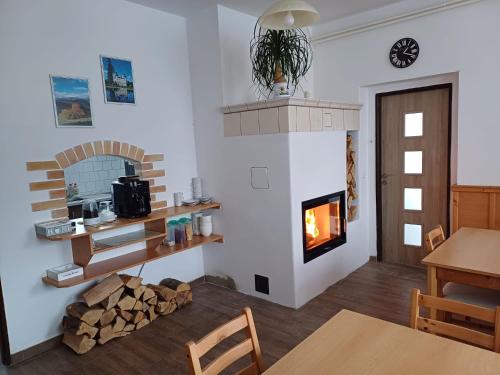 a living room with a fireplace and a table at Pension Kobr in Vrchlabí