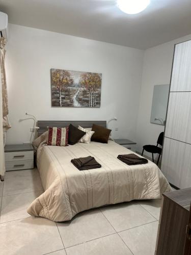ein Schlafzimmer mit einem großen Bett mit zwei Handtüchern darauf in der Unterkunft Orchidea Appartment in Għajnsielem