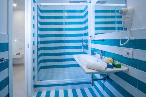 un bagno blu e bianco con lavandino e doccia di Deluxe Apartment in Sorrento Centre a Sorrento