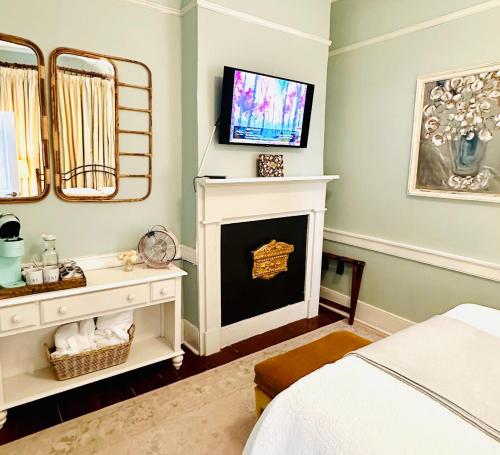 um quarto com lareira e uma televisão na parede em Bijou Boutique Inn em Charleston