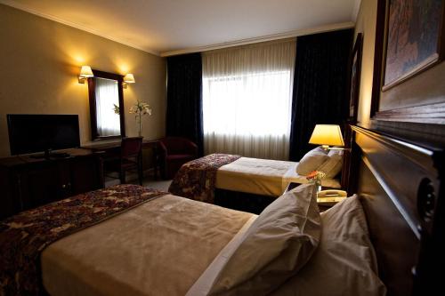 Un pat sau paturi într-o cameră la Naindo Park Hotel