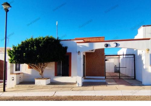 a white house with a tree in front of it at Casa Villa Serena 21 in San Carlos