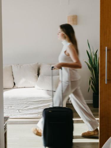a woman walking through a living room with a suitcase at Voramar in Benicàssim