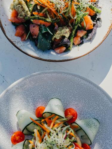 two plates of food with vegetables on a table at Voramar in Benicàssim