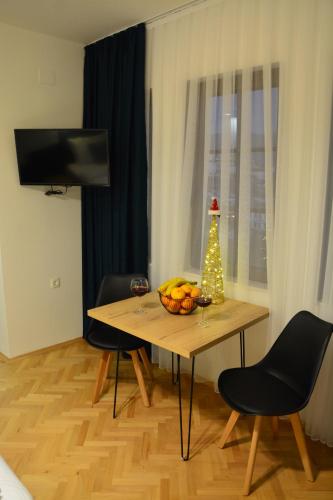 - une table avec un bol de fruits et un arbre de Noël dans l'établissement Miryana Guest House, à Ohrid