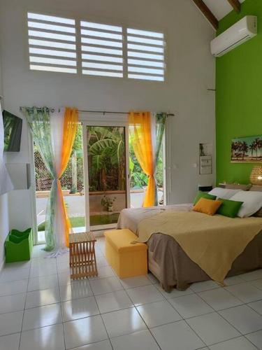 a bedroom with a large bed and a large window at Jeune Tournesol (Bungalow neuf) in Sainte-Anne