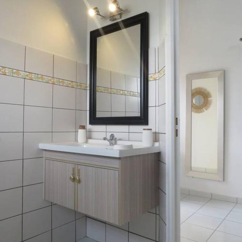 La salle de bains est pourvue d'un lavabo et d'un miroir. dans l'établissement Jeune Tournesol (Bungalow neuf), à Sainte-Anne
