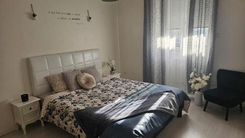 1 dormitorio con 1 cama, 1 silla y 1 ventana en LA DOLCE VITA, en Oyonnax