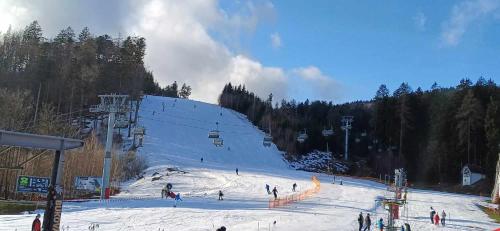a group of people on a snow covered ski slope at Chata Štíty in Štíty