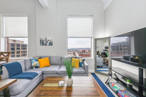 a living room with a couch and a table at King Bed, Downtown Steps from Bengals & Reds, Minutes to OTR, TQL, HardRock in Cincinnati