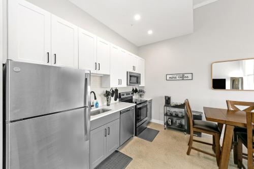 a kitchen with a stainless steel refrigerator and a table at King Bed, Downtown Steps from Bengals & Reds, Minutes to OTR, TQL, HardRock in Cincinnati