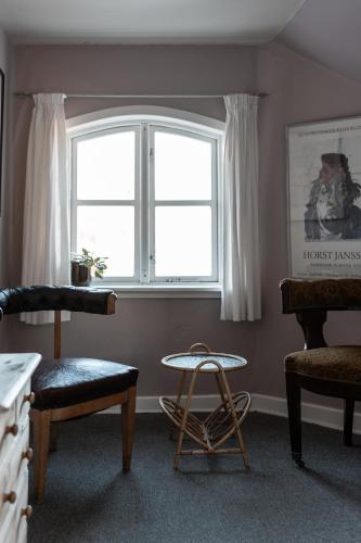 a room with a window and a chair and a table at Cafe Sallys bed and breakfast in Ribe