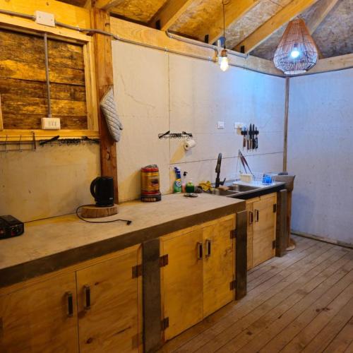 a kitchen with wooden cabinets and a counter top at Cabañas rio Biobio in Callaqui