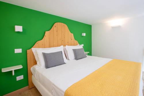 a bedroom with a large bed with a green wall at Sorrento Villa with Pool and Amazing Views in Massa Lubrense