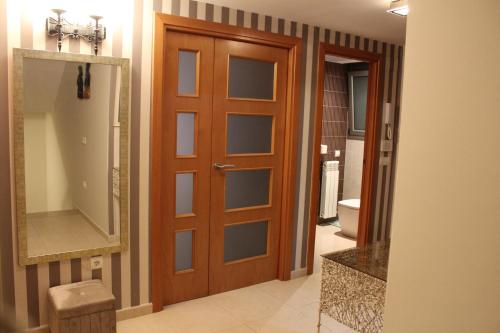 a bathroom with a wooden door and a mirror at Residentium Spain -Chalet la Dorada pets friendly in Cambrils
