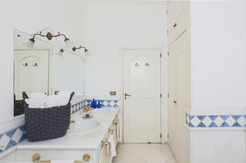 W białej łazience znajduje się umywalka i lustro. w obiekcie Luxury Family Amalfi Coast Villa w mieście Piano di Sorrento