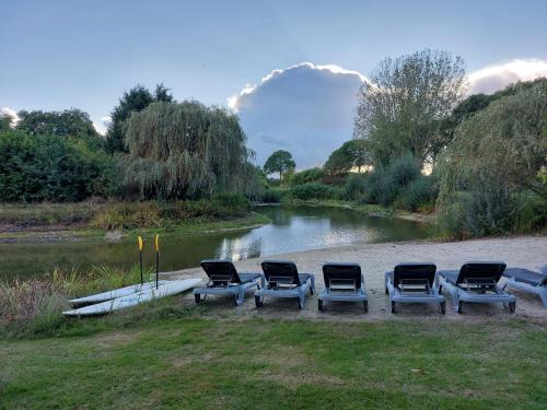 a group of chairs sitting next to a river at Ottenskamp4 en Het Achterhuis in Siebengewald