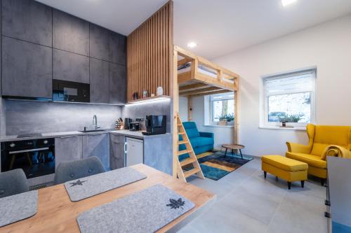 a kitchen and living room with a table and chairs at Apartmán SPORT in Pernink