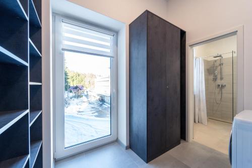 a bathroom with a large window and a shower at Apartmán SPORT in Pernink