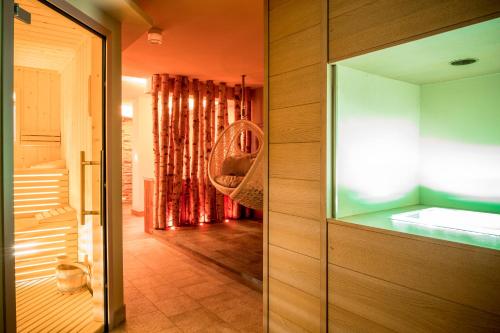 baño con paredes de color naranja y puerta de cristal en Hotel Gries, en Canazei