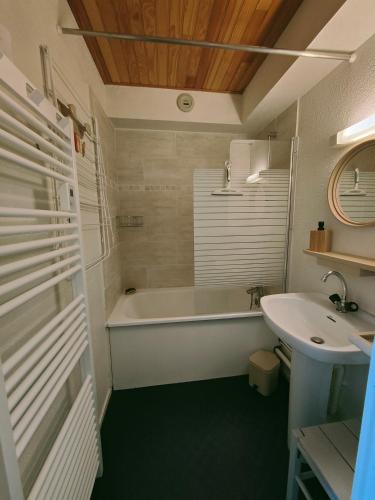 une salle de bain avec une baignoire et un lavabo dans l'établissement Arc 2000 - Charmant appartement 4 personnes, chambre séparée, calme et en plein centre, à Bourg-Saint-Maurice