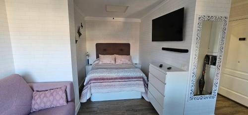 - une petite chambre avec un lit et une télévision dans l'établissement Estudio tranquilo cerca del mar., à Puerto de la Cruz