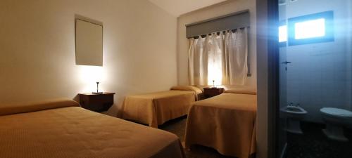 een hotelkamer met twee bedden en een raam bij Hotel Marino in Villa Gesell