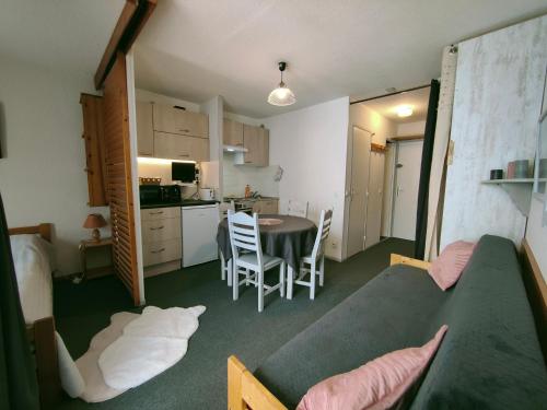 Cette petite chambre dispose d'une cuisine, d'une table et de chaises. dans l'établissement Arc 2000 - Charmant appartement 4 personnes, chambre séparée, calme et en plein centre, à Bourg-Saint-Maurice