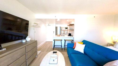 a living room with a blue couch and a kitchen at S&N Lux Suite-Free Parking-King Bed-Kitchen-WiFi in Honolulu